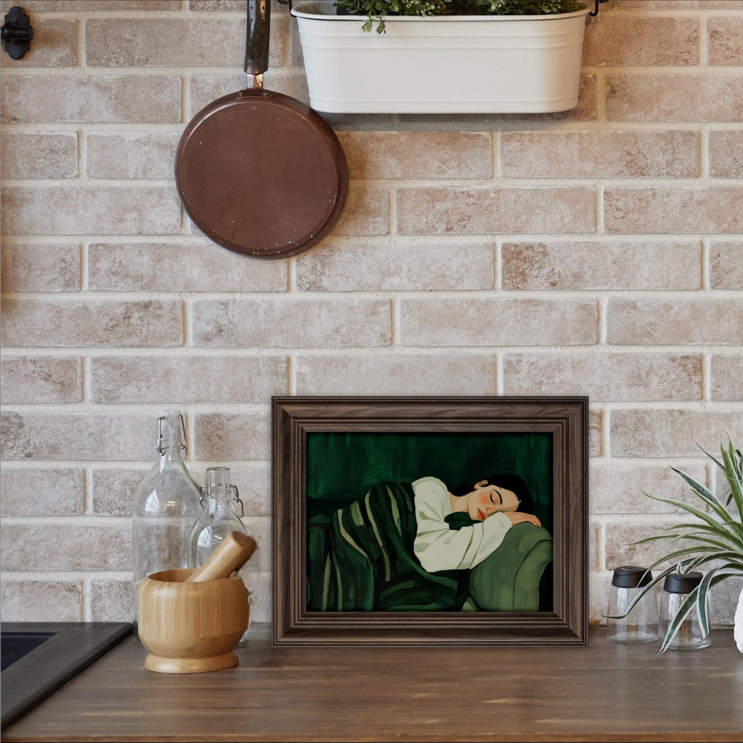 a framed painting of a woman sleeping on a couch, placed on a wooden surface in a kitchen setting.
