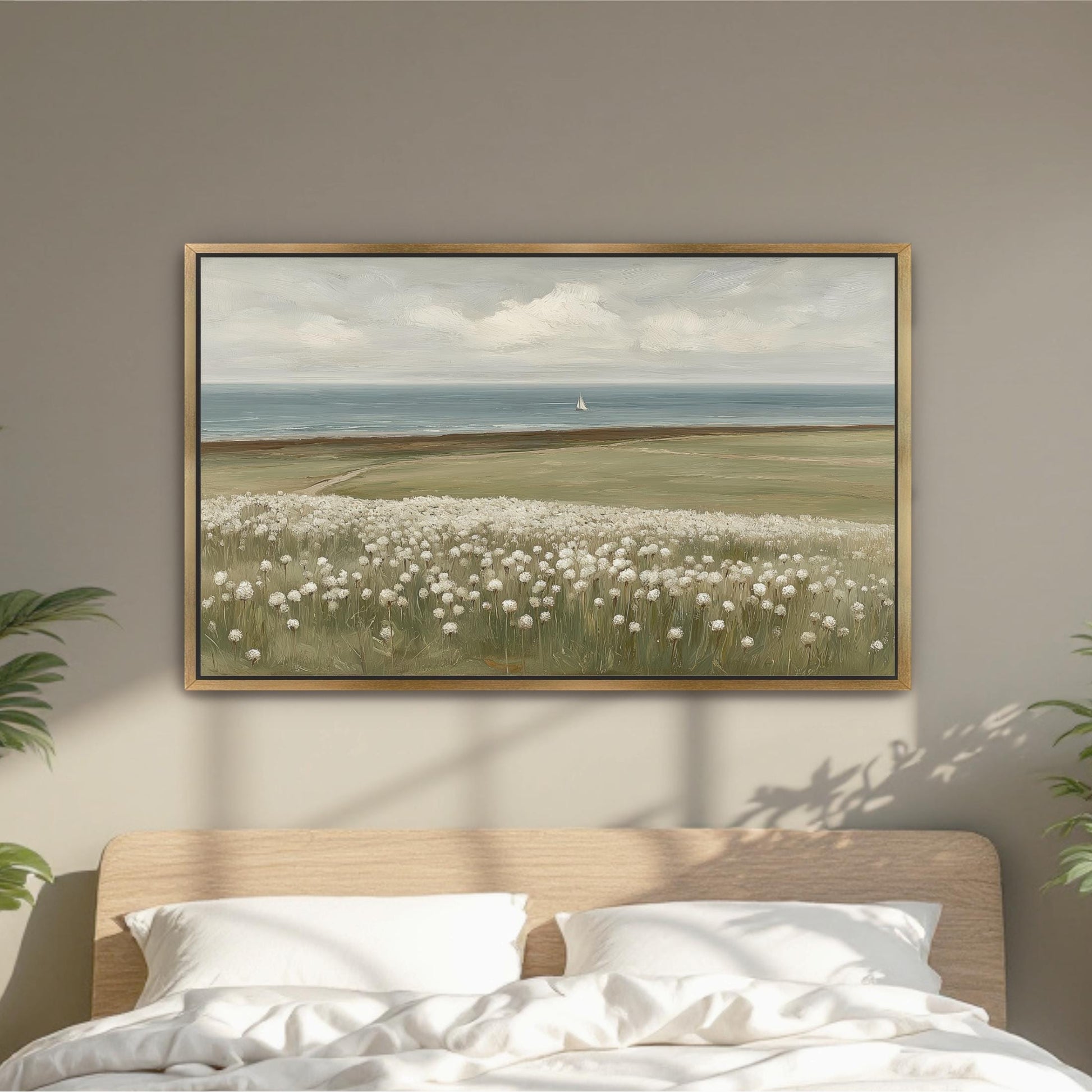 a large painting of a field with white flowers hanging on a wall above a bed with white pillows.