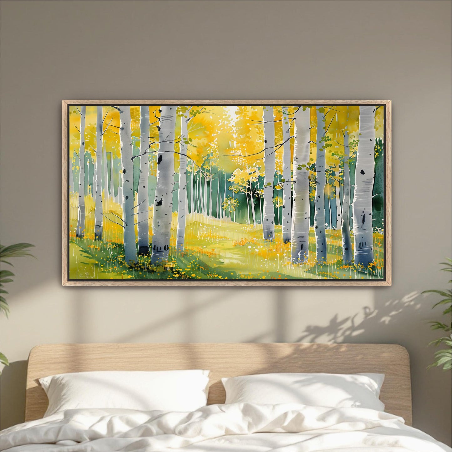 a large, framed painting of a forest scene with tall trees and yellow foliage, hanging on a wall above a bed with white pillows.