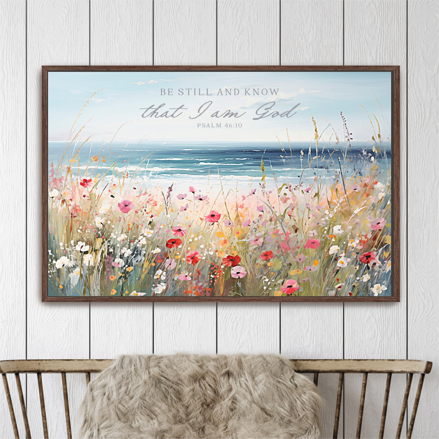 The image is a framed painting depicting a serene landscape with a field of colorful flowers and a body of water in the background.