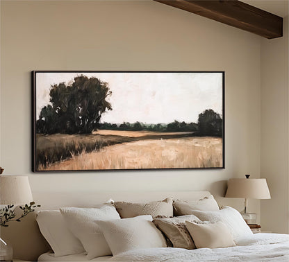 a large painting of a field hanging on a wall above a bed with white pillows and a white headboard.