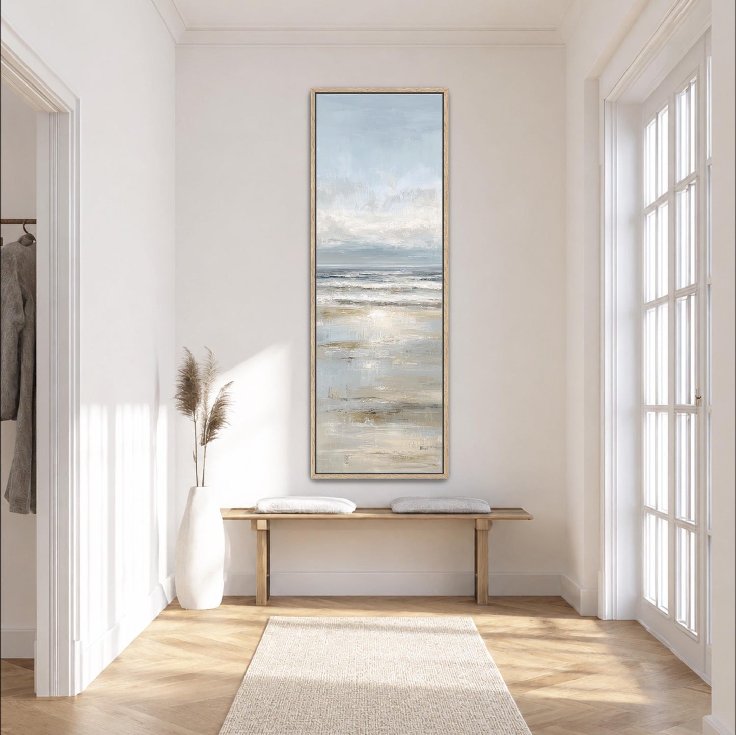 a serene and minimalist interior design, featuring a large painting of a beach scene hanging on the wall, a wooden bench, a white vase with dried flowers, and a large window that allows natural light to flood the space.