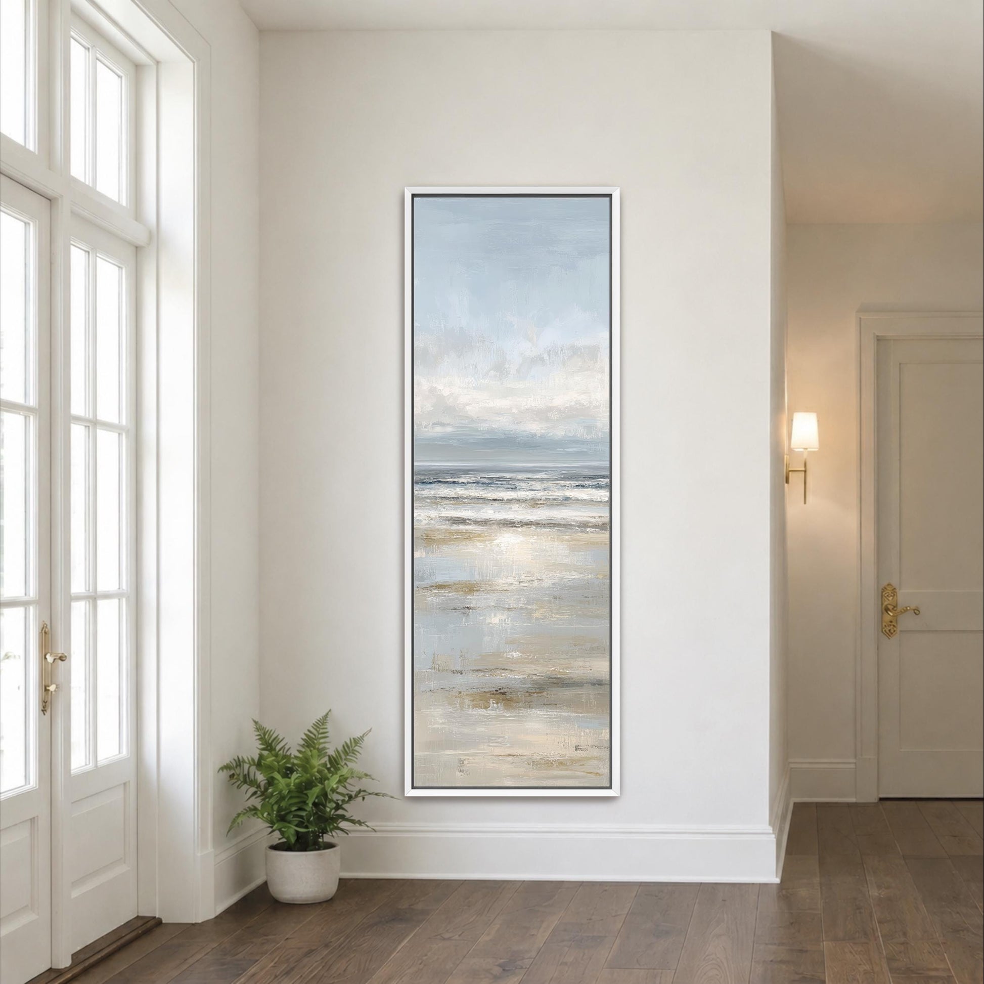 a large painting of a serene beach scene hanging on a white wall in a bright, airy room with large windows.