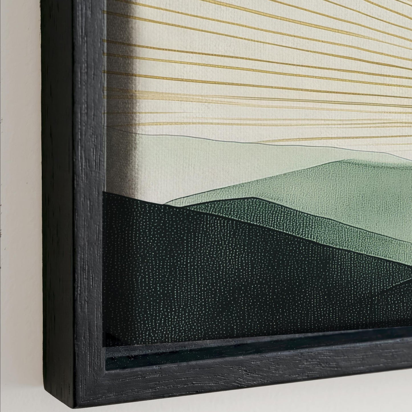The image is a framed artwork depicting a landscape with mountains and hills. The artwork has a dark frame and a black border, creating a contrast with the lighter colors of the landscape.