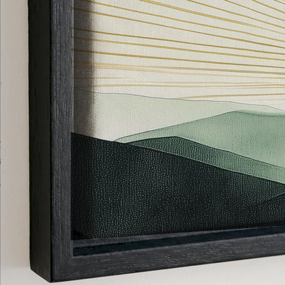 The image is a framed artwork depicting a landscape with mountains and hills. The artwork has a dark frame and a black border, creating a contrast with the lighter colors of the landscape.