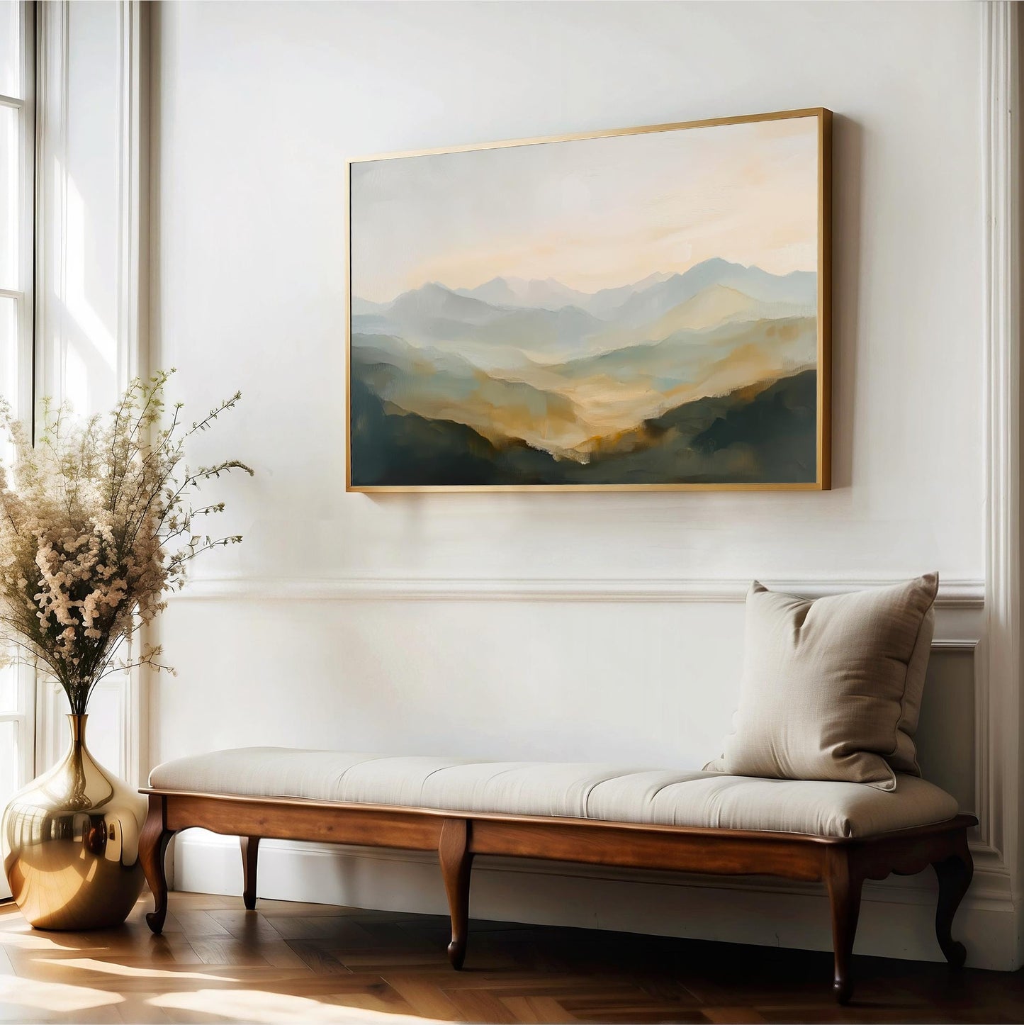 a large landscape painting hanging on a white wall above a wooden bench with a beige cushion. The painting depicts a serene mountain scene with a warm, hazy color palette.