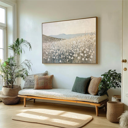 a living room with a large painting of a field of flowers hanging on the wall above a couch with pillows. The room is decorated with potted plants and a rug, creating a cozy and inviting atmosphere.