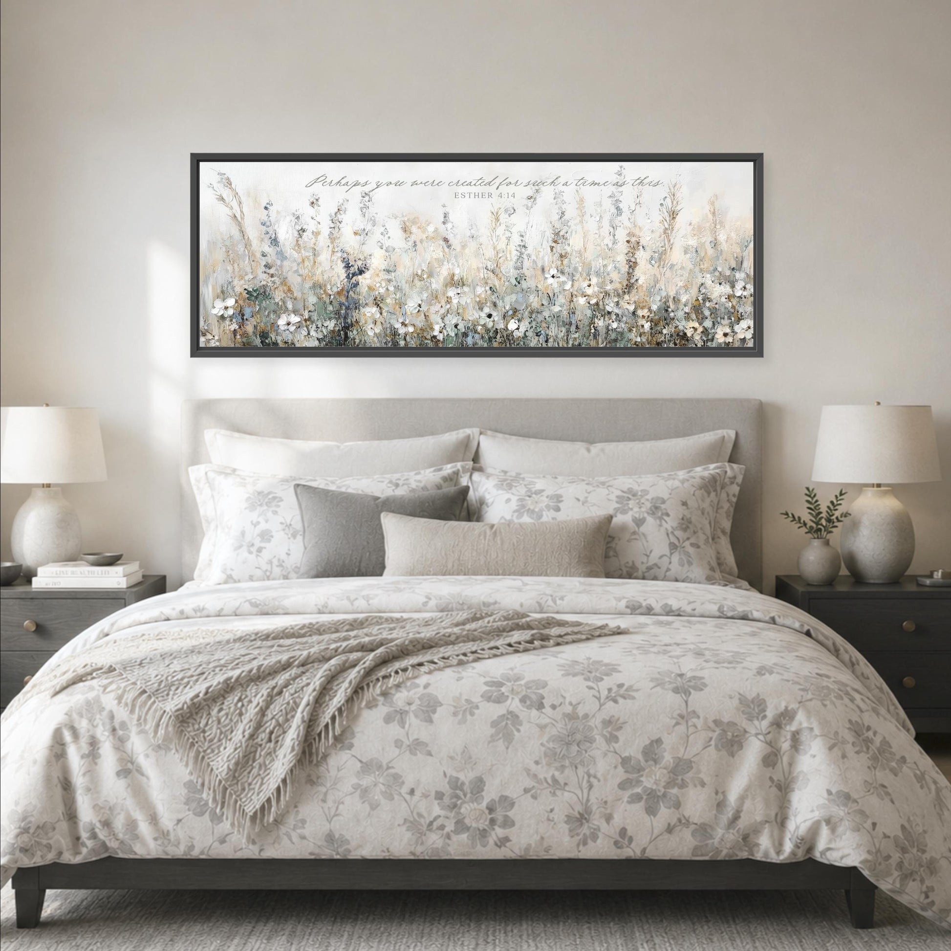 a large bed with a floral bedspread and pillows, flanked by two nightstands with lamps. Above the bed is a framed artwork depicting a field of flowers.