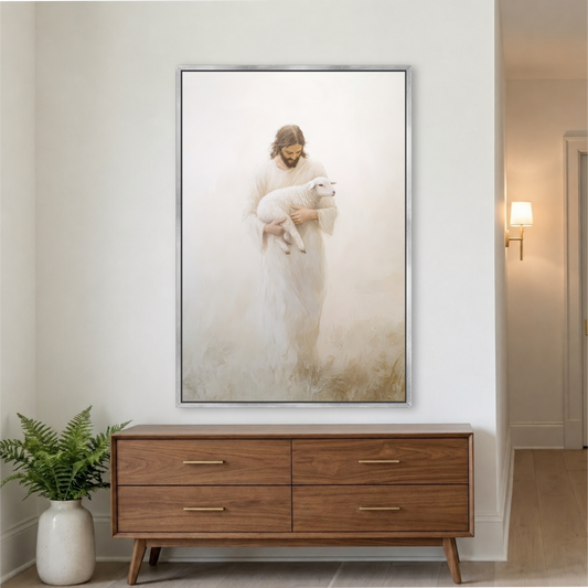 a large framed painting of Jesus Christ holding a lamb, hanging on a white wall above a wooden dresser.