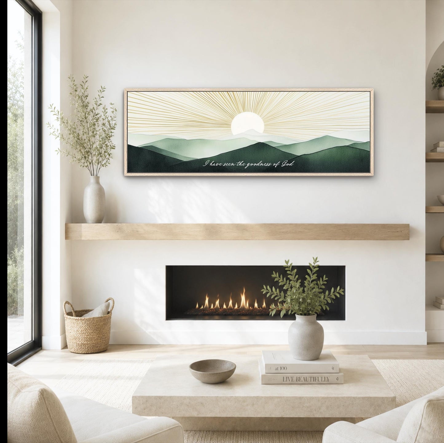 A modern living room with a fireplace, a coffee table, and a framed artwork depicting a sunrise over mountains.