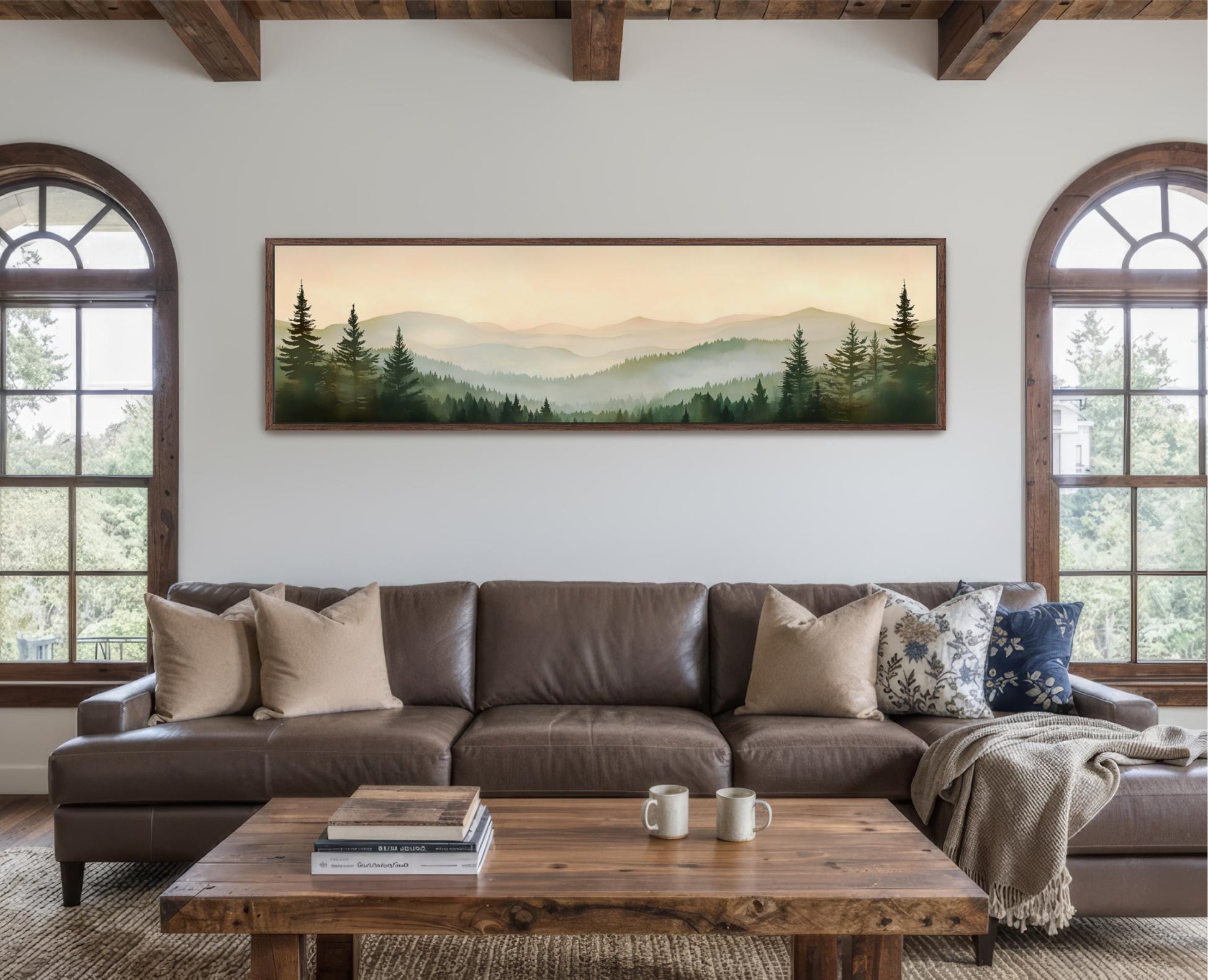 a large framed landscape painting hanging on a wall above a brown leather couch in a cozy living room setting.