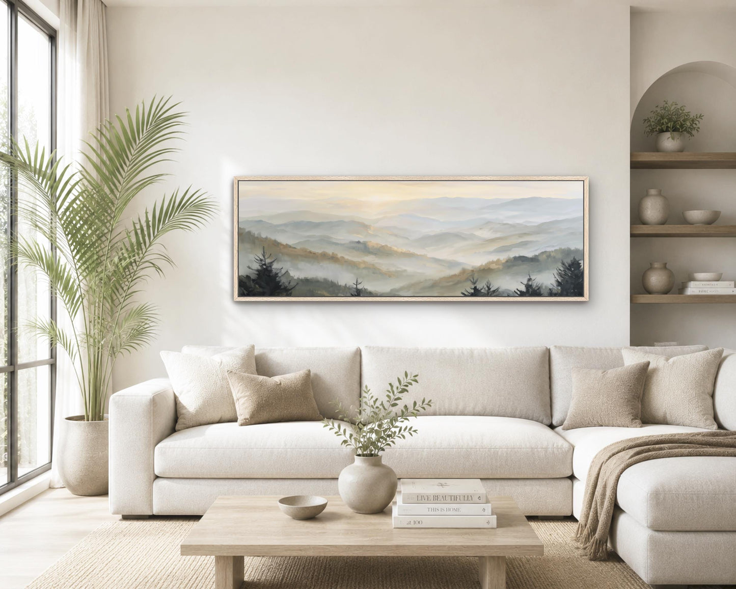 a serene living room with a large, framed landscape painting hanging on the wall above a white sofa. The painting features a scenic mountain landscape with a hazy, golden-hued sky. The room is decorated with various plants, vases, and books, creating a cozy and inviting atmosphere.