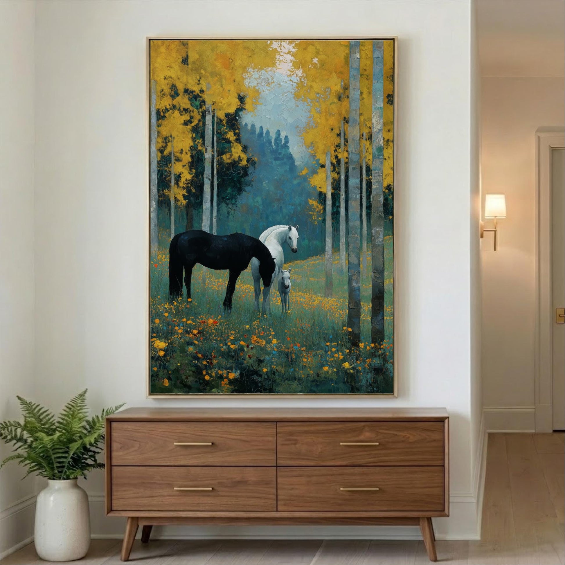 a large painting of two horses in a forest setting, with one horse being black and the other white. The painting is hanging on a wall above a wooden dresser.