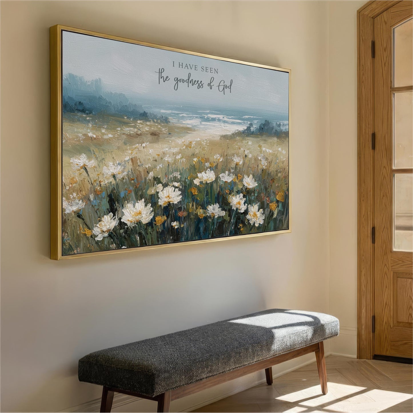 a large painting of a field of flowers hanging on a wall, with a bench in front of it.