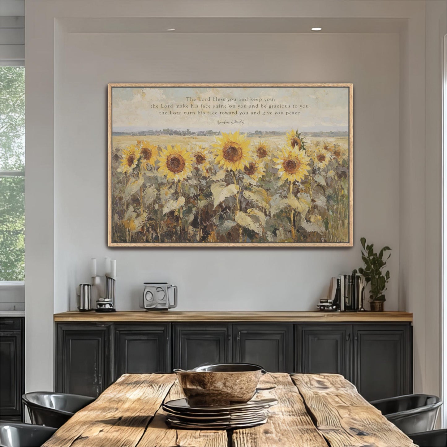 a large painting of a field of sunflowers hanging on a wall above a wooden dining table with a bowl on it.