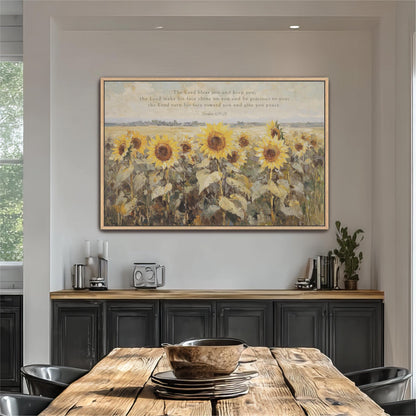 a large painting of a field of sunflowers hanging on a wall above a wooden dining table with a bowl on it.