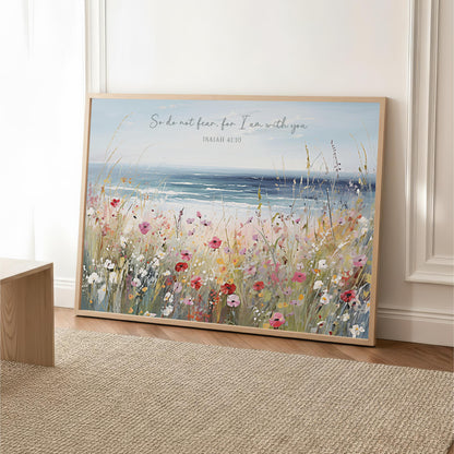 A framed painting depicting a serene landscape with a field of colorful flowers and a body of water in the background.