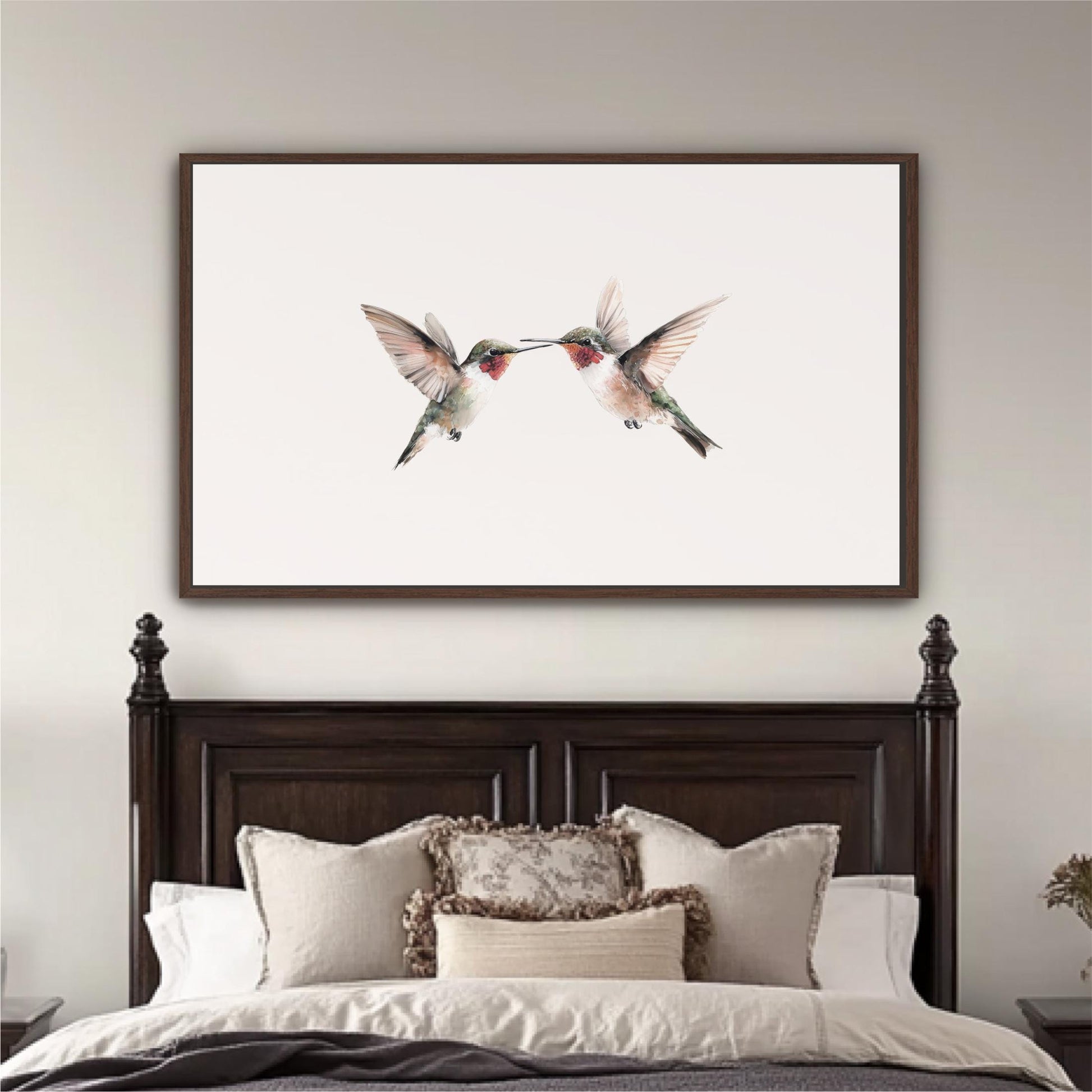 a large framed picture of two hummingbirds on a white background, hanging above a bed with a dark wooden headboard.