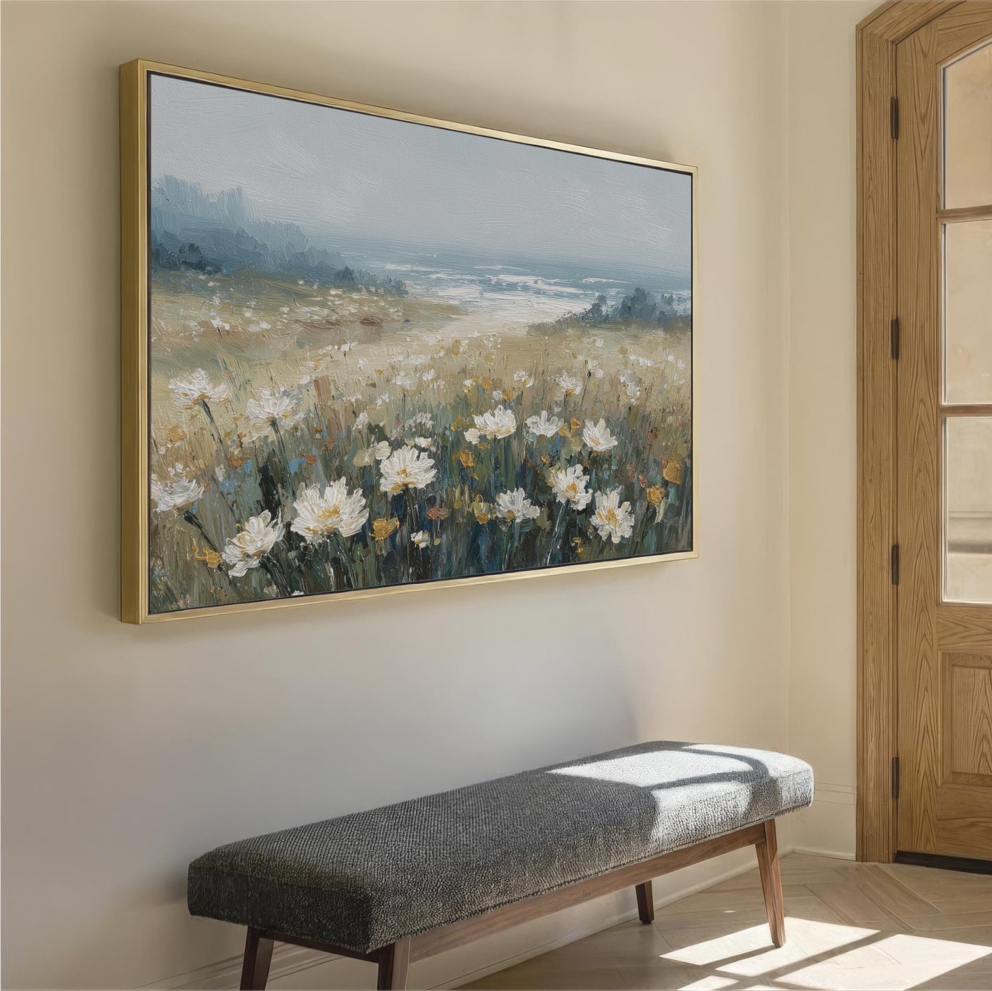 a large painting of a field of flowers hanging on a wall, with a bench placed in front of it.