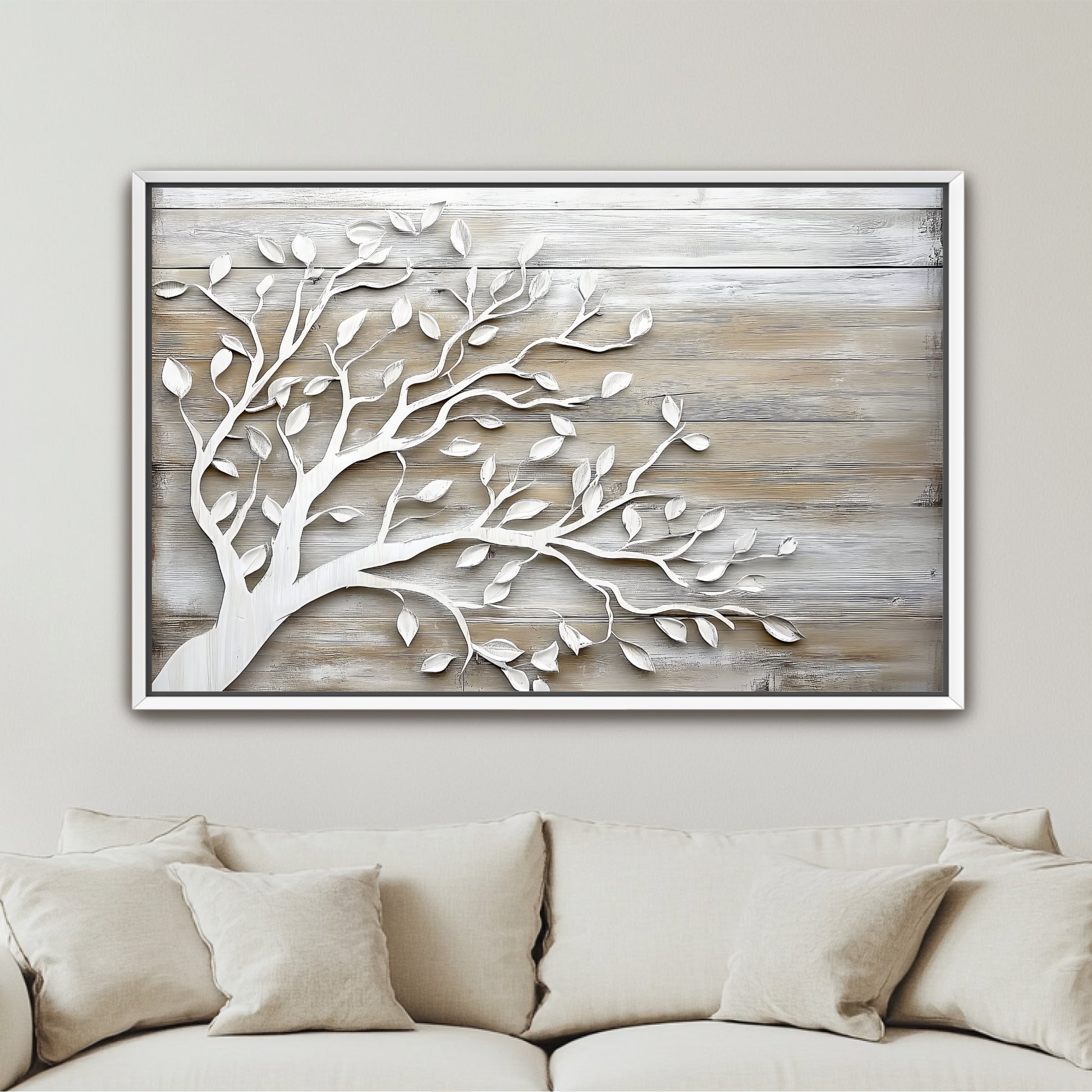 a framed artwork of a tree with white leaf patterns on a wooden background, hanging on a wall above a beige couch.