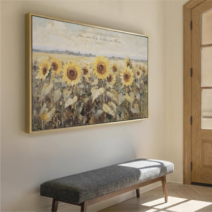 a large painting of a field of sunflowers hanging on a wall, with a bench in front of it.