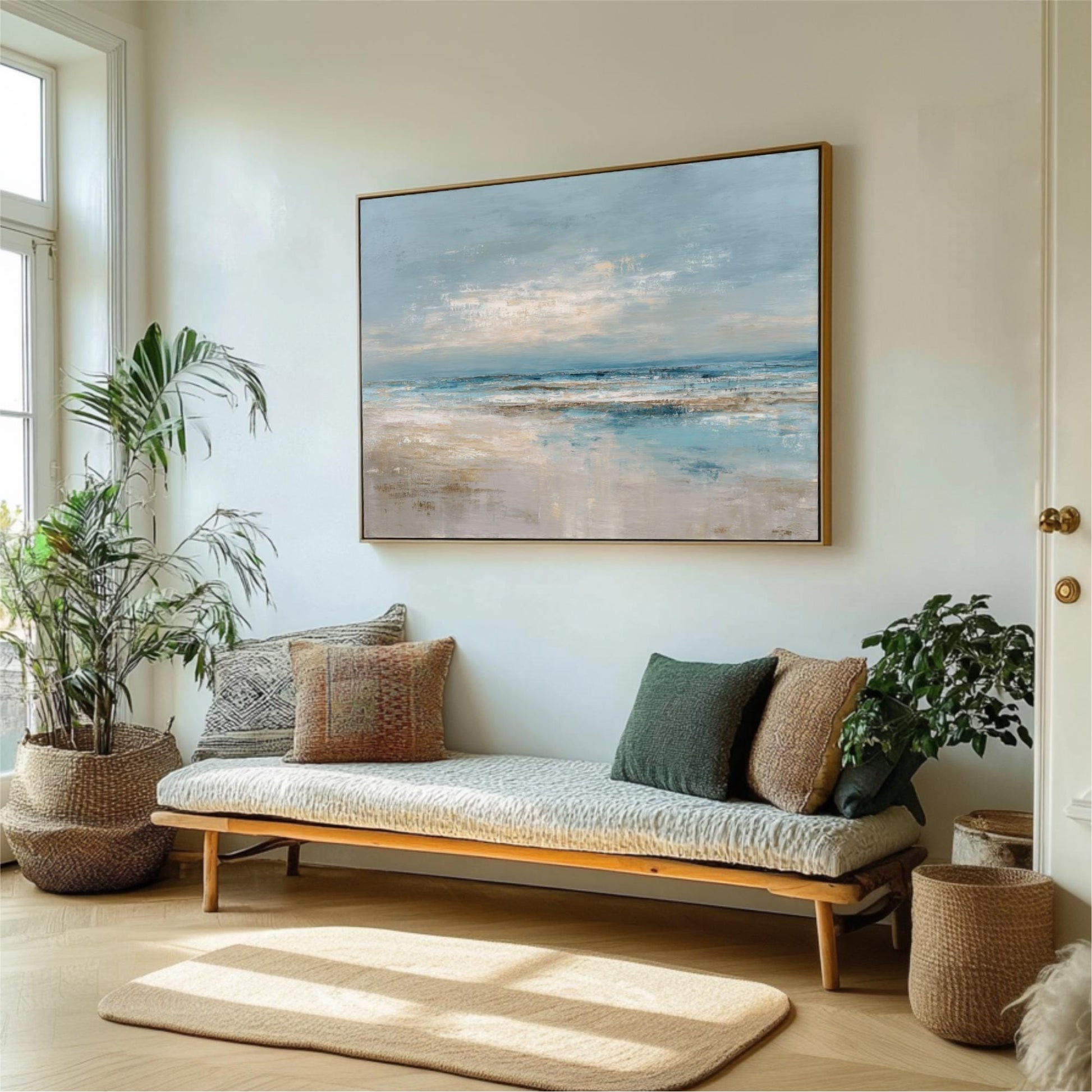 a living room with a large painting of a beach scene hanging on the wall above a wooden bench with pillows. The room is decorated with potted plants and a rug, creating a cozy and inviting atmosphere.