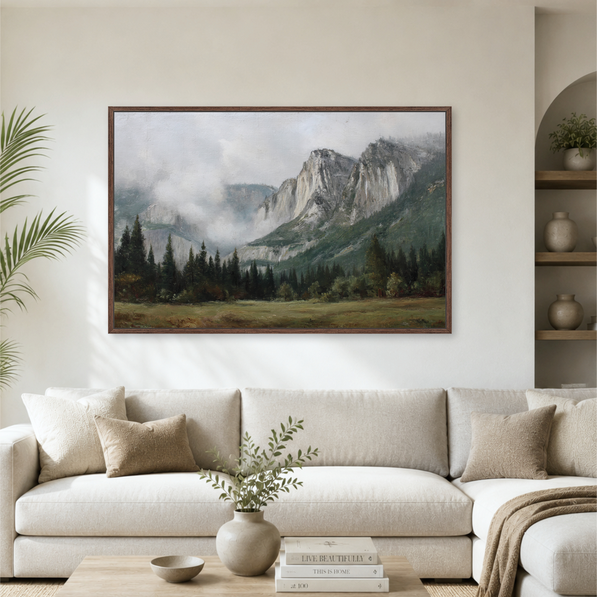 a large landscape painting hanging on a wall above a white sofa in a living room.