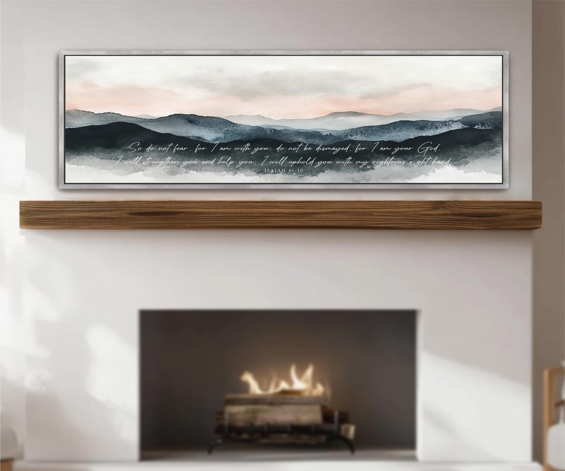 a fireplace with a warm fire burning inside, and above it is a framed painting depicting a serene landscape with mountains and a cloudy sky.