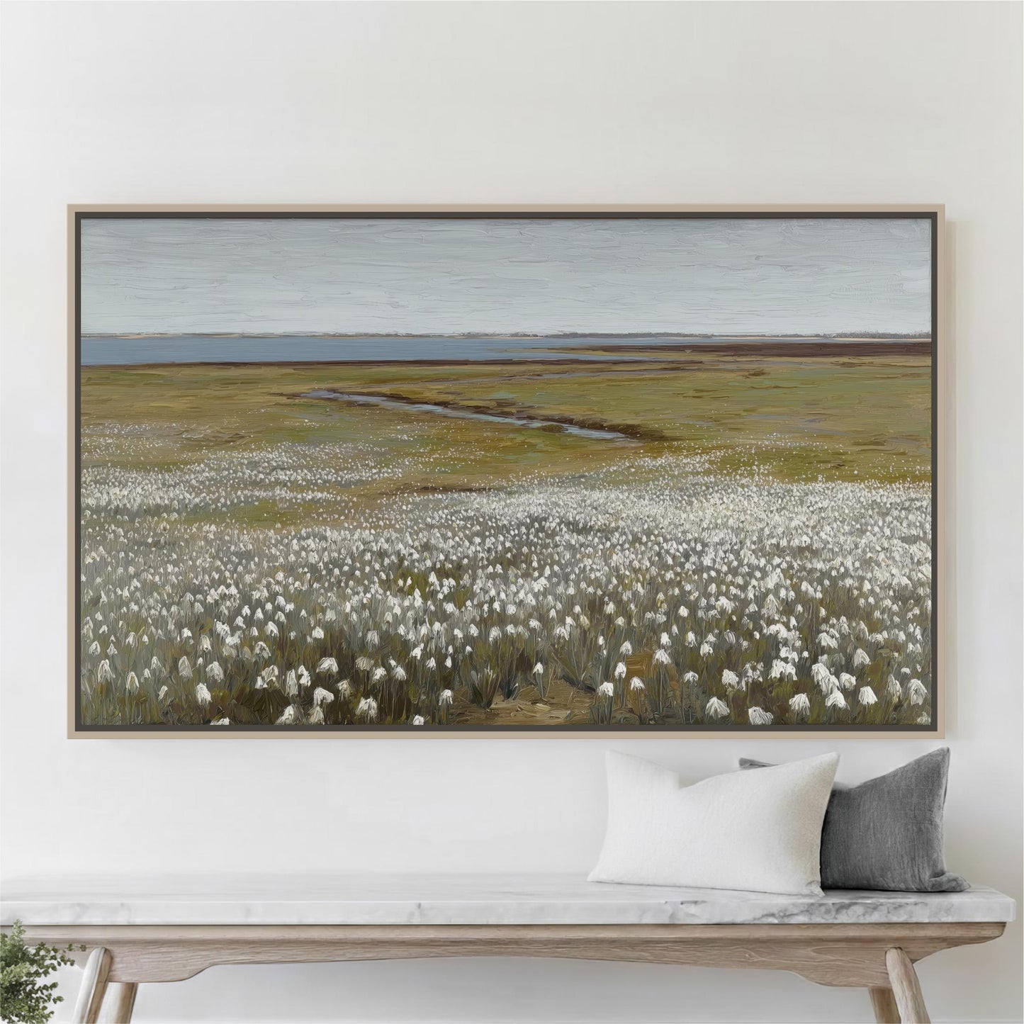 a large painting of a field with white flowers hanging on a wall above a wooden bench.