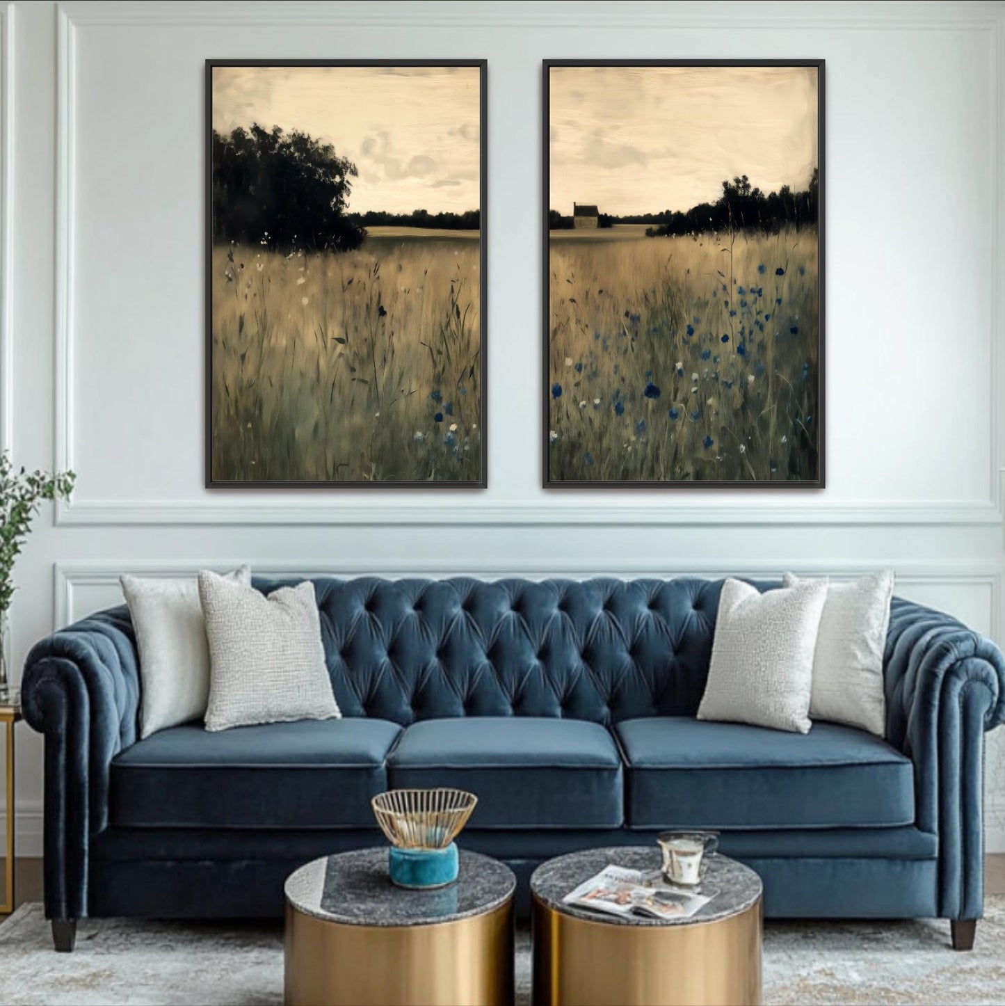 a living room with a blue tufted sofa, two framed landscape paintings on the wall, and a coffee table in front of the sofa.
