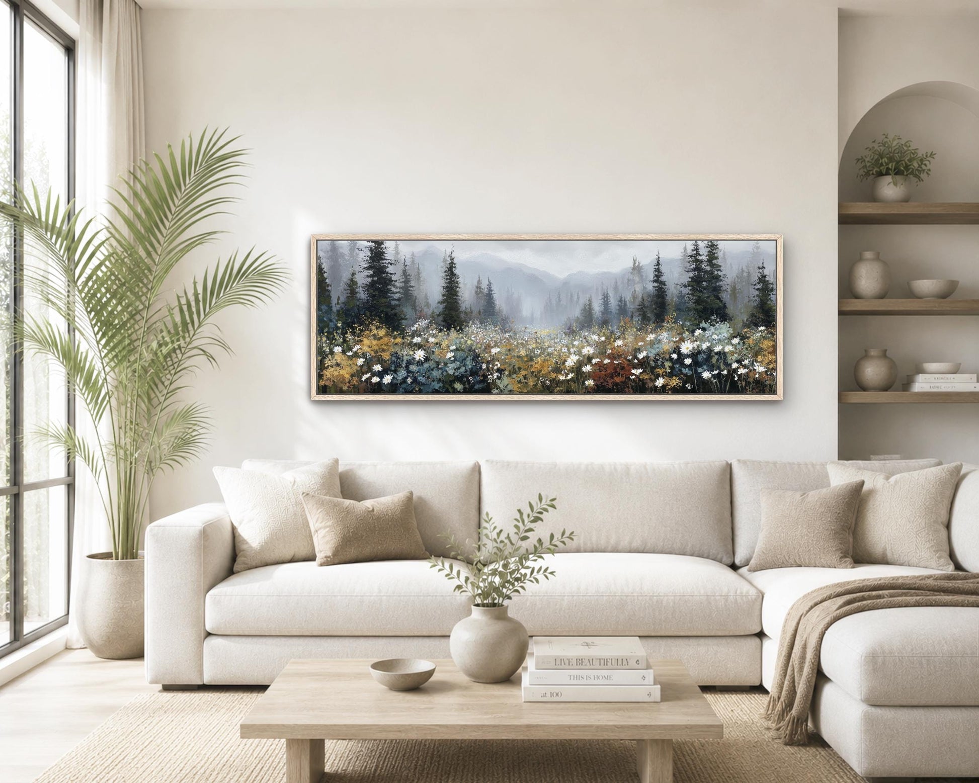 a cozy living room with a large, framed landscape painting hanging on the wall above a white sofa. The painting features a forest scene with trees and flowers, creating a serene and natural atmosphere. The room is decorated with various plants, vases, and books, contributing to a warm and inviting ambiance.