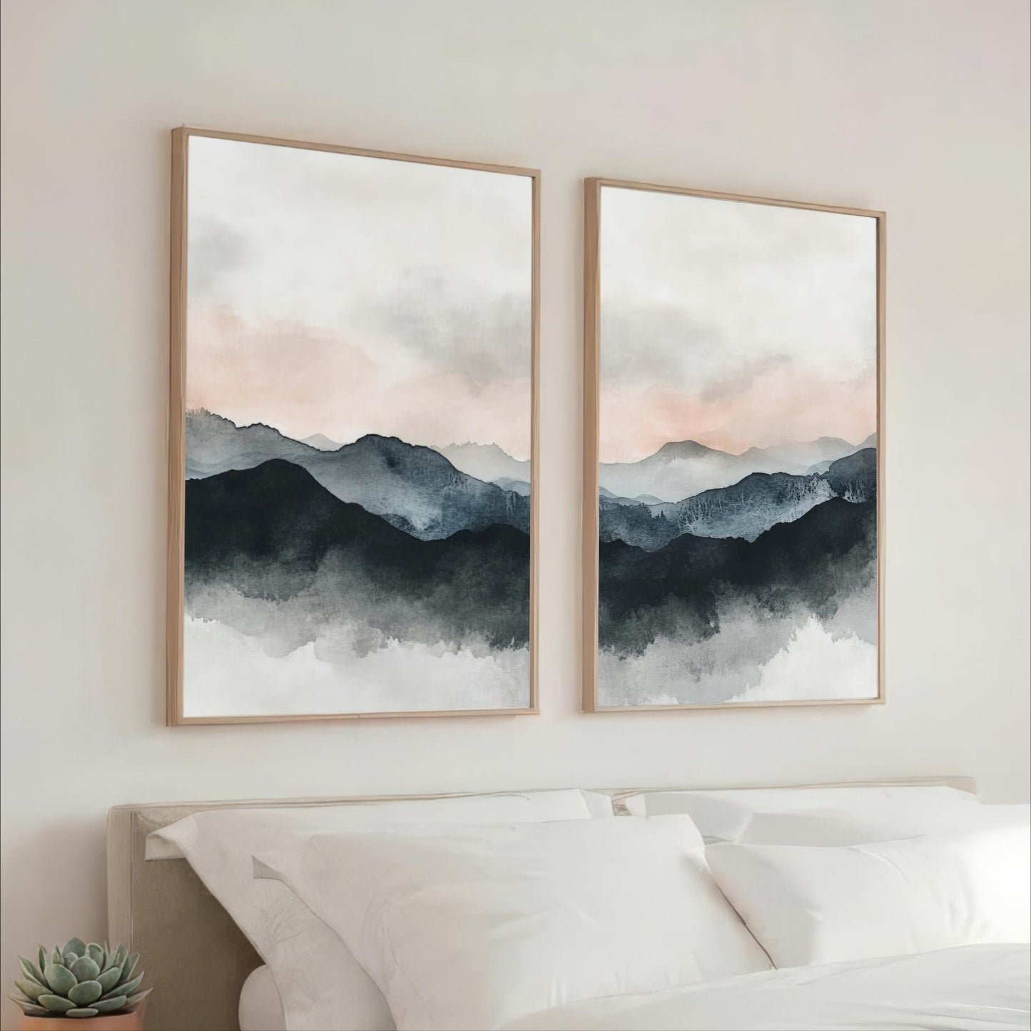 two large framed paintings hanging on a wall above a bed, depicting a serene landscape with mountains and a cloudy sky.
