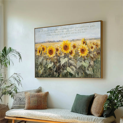 a large framed painting of a field of sunflowers hanging on a wall, with a potted plant and a couch in the foreground.
