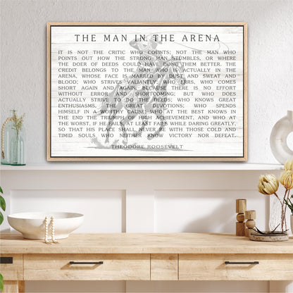 a framed quote by Theodore Roosevelt, a famous American president, displayed on a wall above a wooden shelf with various decorative items.