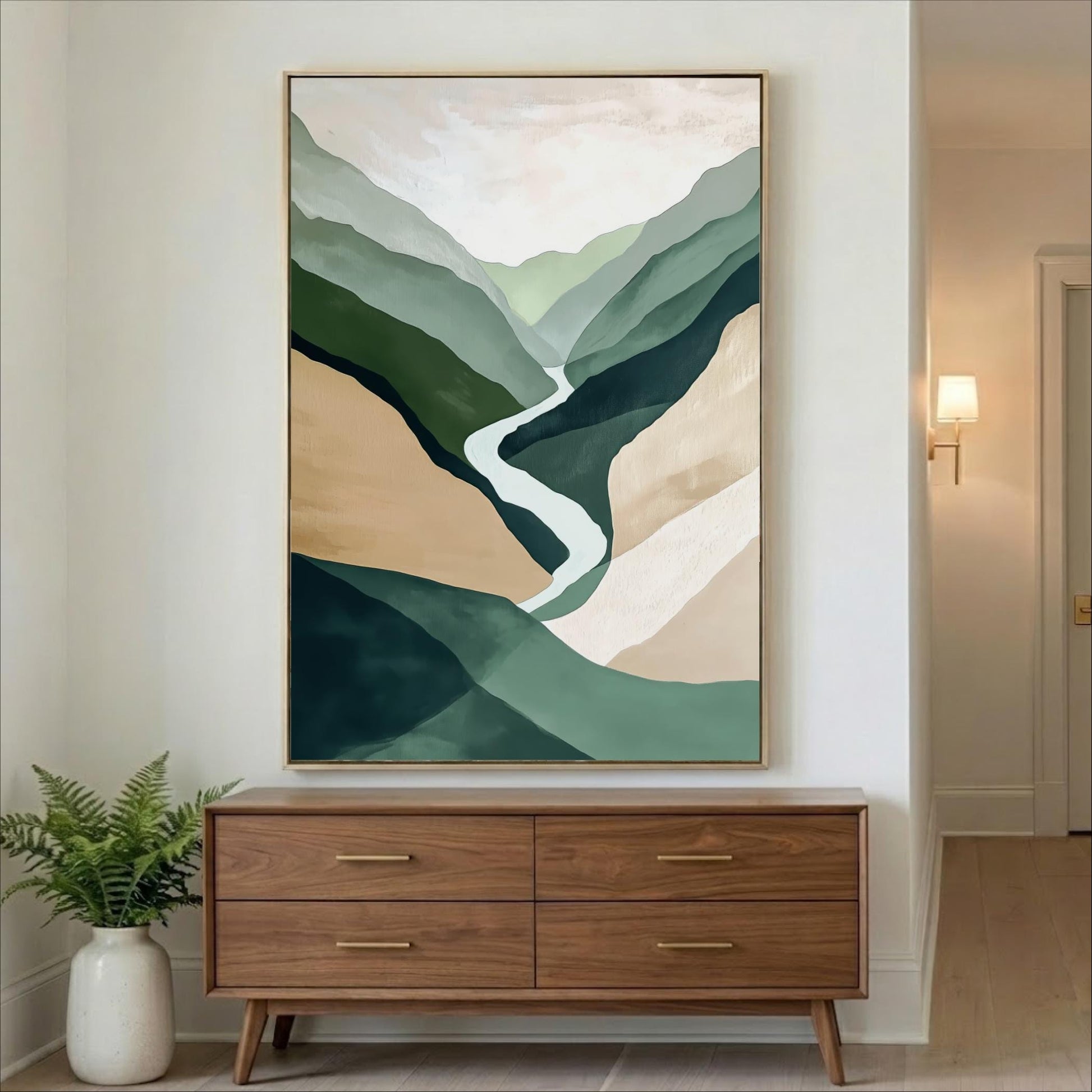 a large abstract painting hanging on a wall above a wooden dresser with four drawers. The painting depicts a winding path through a mountainous landscape with shades of green, brown, and beige.