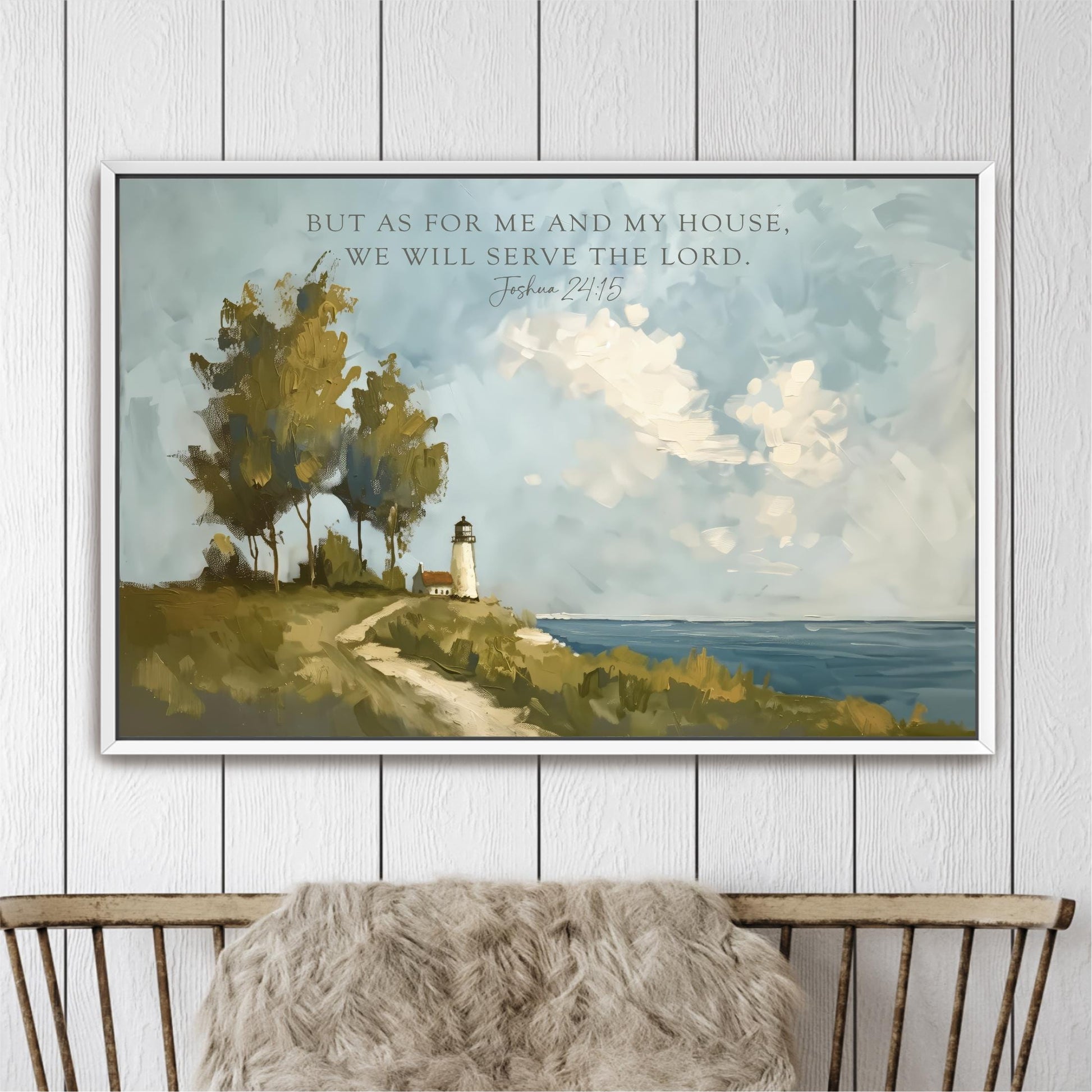 A framed painting depicting a lighthouse on a hill overlooking the ocean, with a text overlay that reads "But as for me and my house, we will serve the Lord. Joshua 24:15".