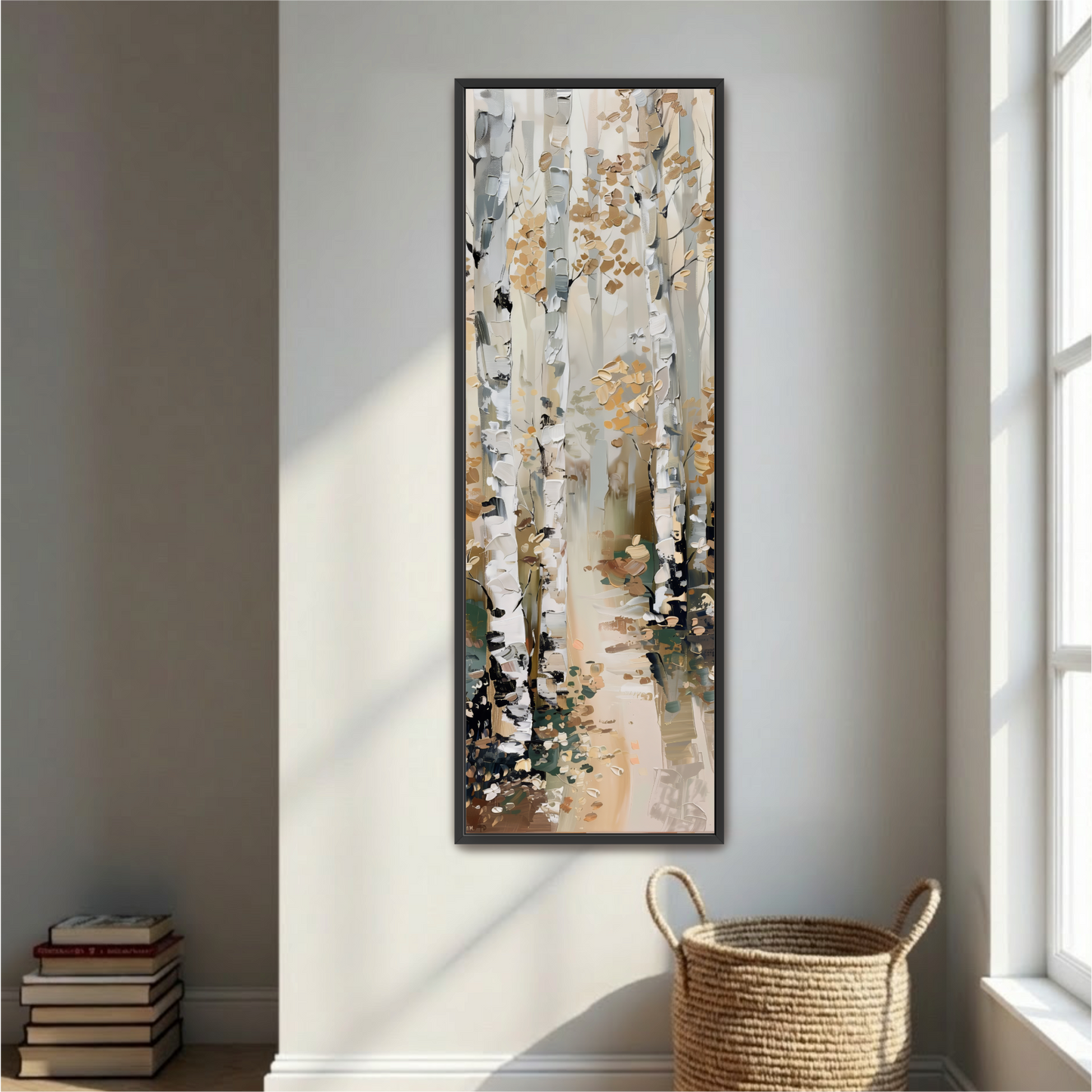 a large painting of a forest scene hanging on a white wall, with a stack of books and a woven basket placed next to it.