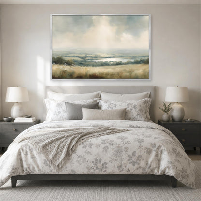a serene bedroom scene with a large bed adorned with a floral comforter and pillows, flanked by two nightstands with lamps. Above the bed, a large landscape painting hangs on the wall, adding an artistic touch to the room's decor.