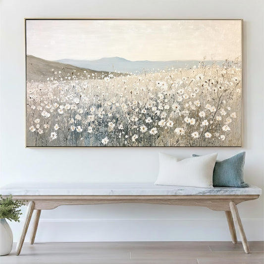 a large painting of a field of flowers hanging on a wall above a wooden bench with pillows.