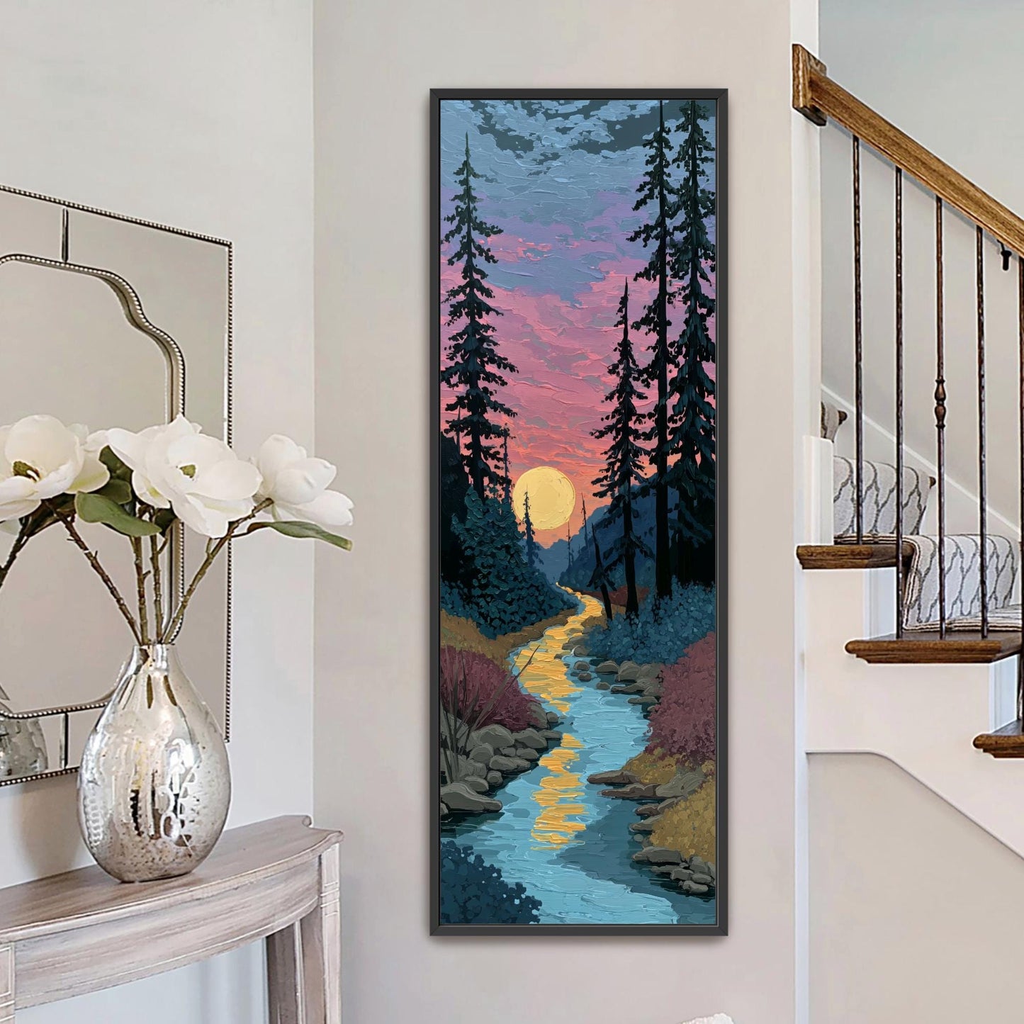 a large painting of a serene landscape with a winding river, trees, and a sunset sky. The painting is hung on a wall next to a staircase.
