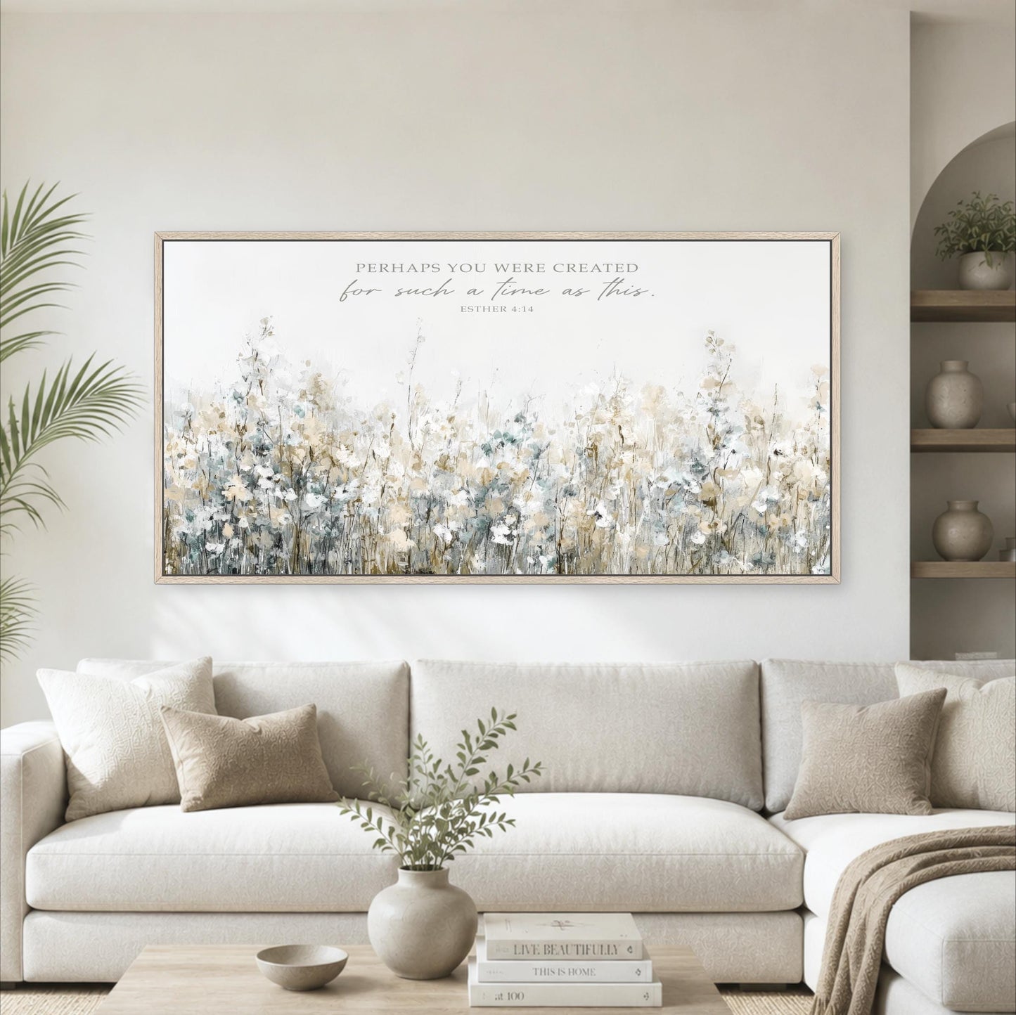 a large, framed painting of a field of flowers hanging on a wall above a white couch in a living room.