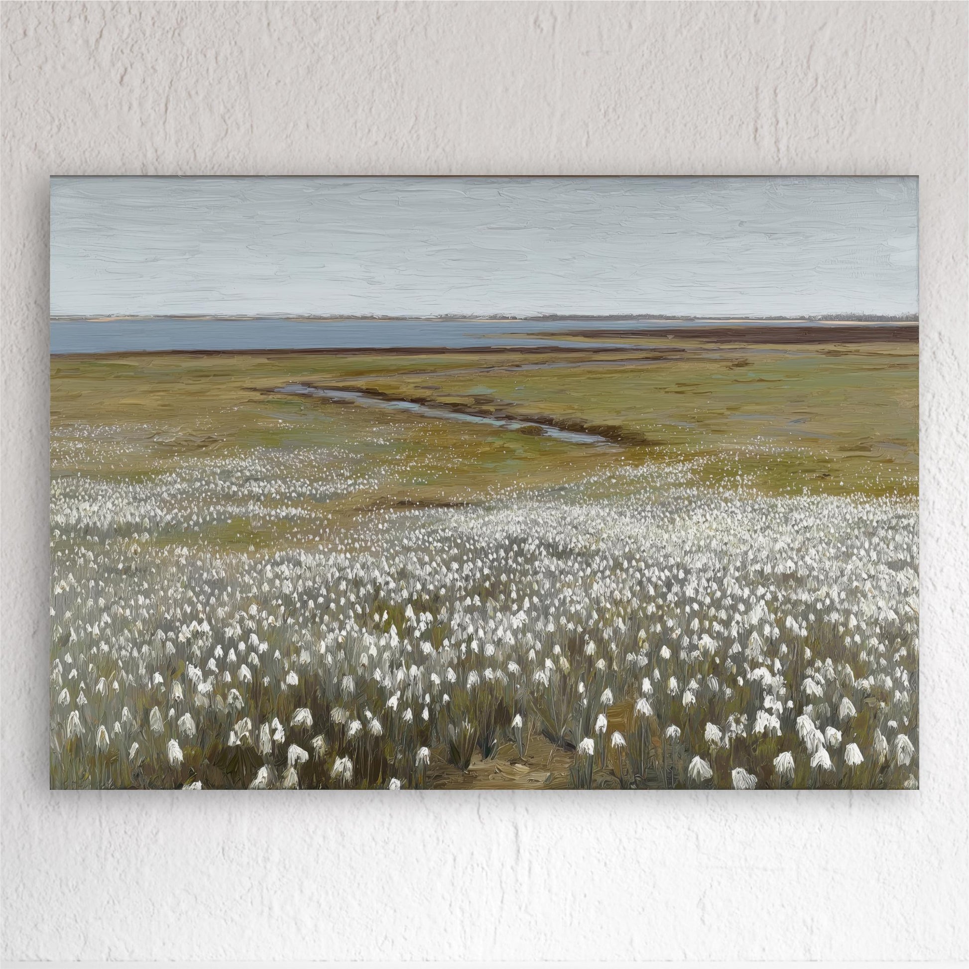A large field of white flowers stretches out in the foreground, leading to a body of water in the distance.