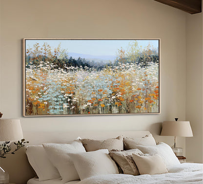 a large, framed painting of a field of flowers hanging on a wall above a bed with white bedding.