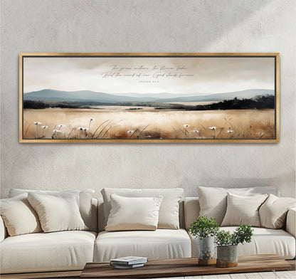 a large framed painting of a serene landscape with a field of flowers and mountains in the background, hanging on a wall above a beige sofa with white pillows.