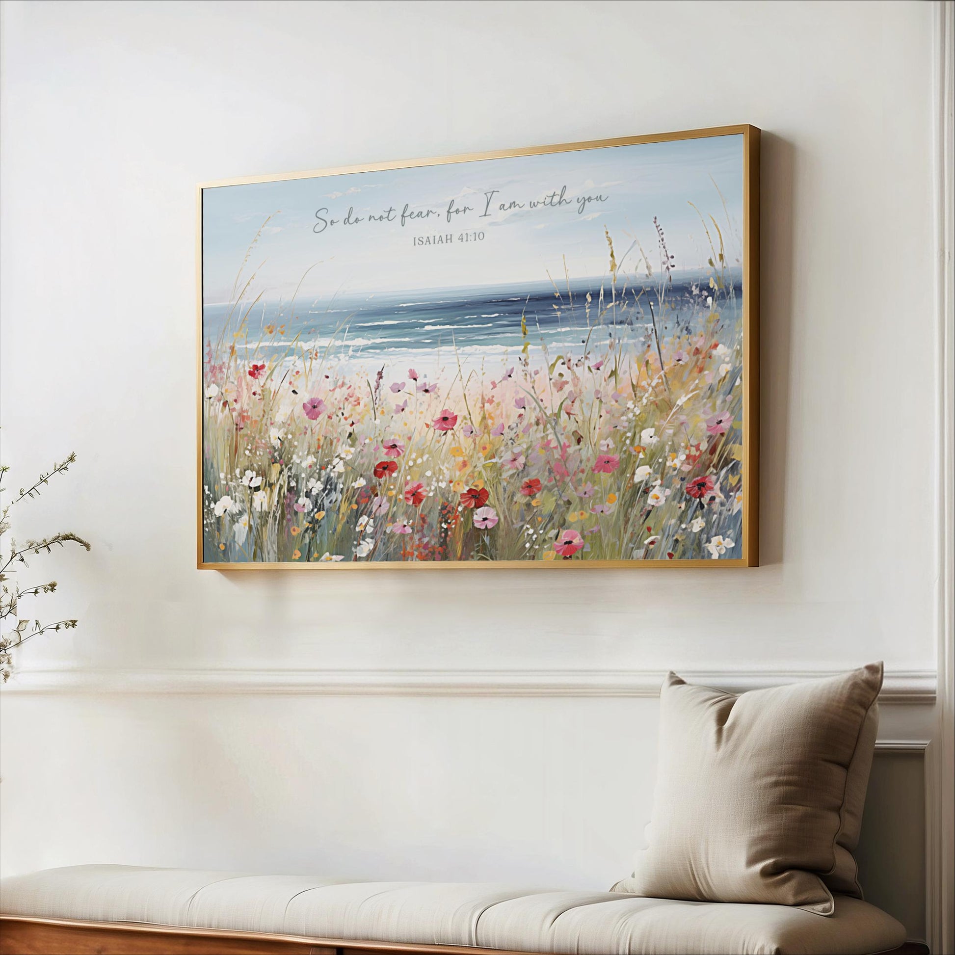 a large framed painting of a field of flowers hanging on a wall, with a bench and a plant in the foreground.