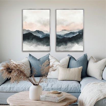 a living room with a blue couch, a coffee table, and two framed landscape paintings hanging on the wall above the couch.