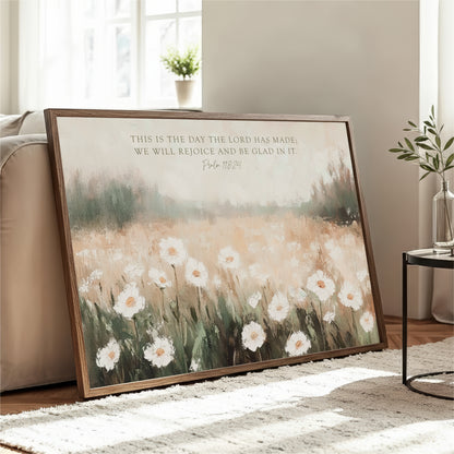 a large framed painting of a field of white flowers, with a potted plant and a vase visible in the background.