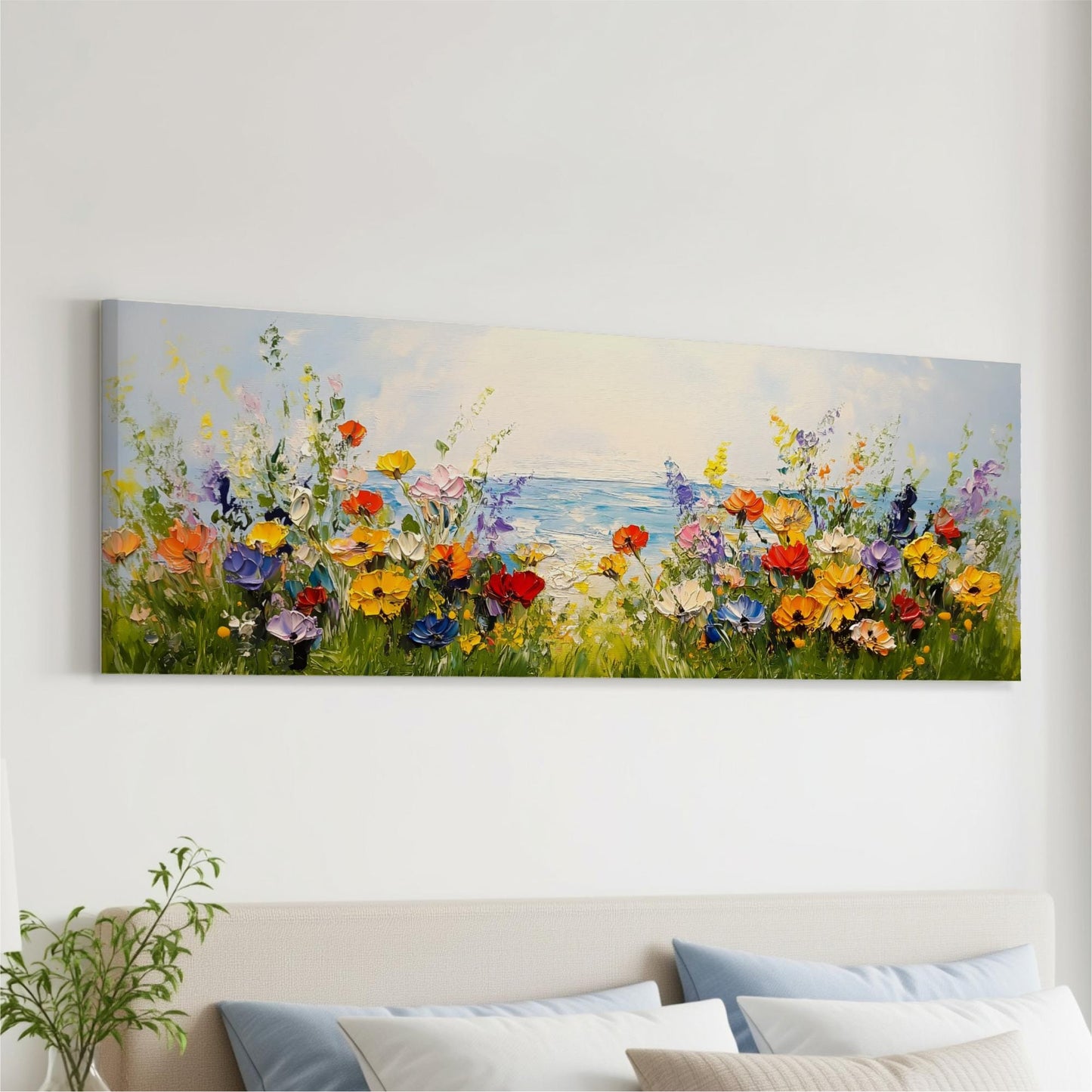 a large, colorful painting of a field of flowers hanging on a wall above a bed with pillows.
