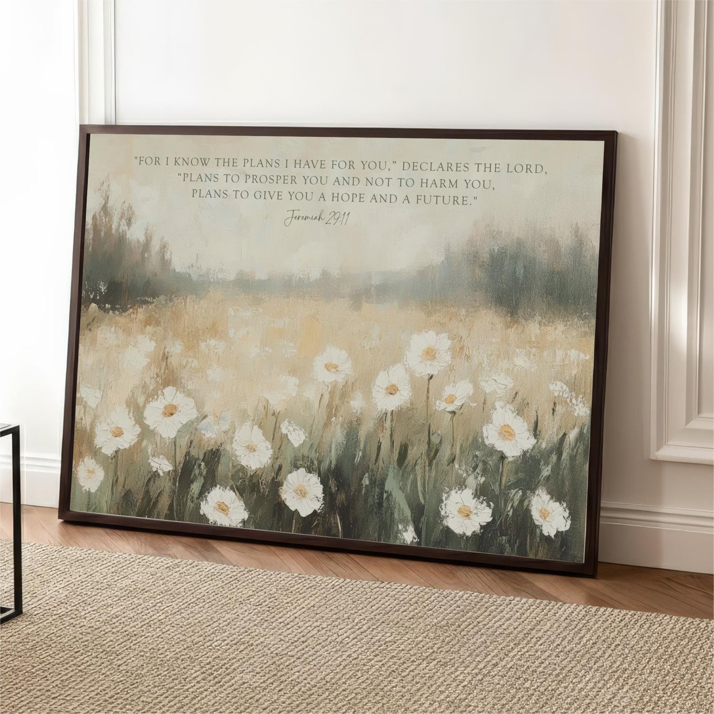 A framed painting of a field of white flowers is displayed on a wall, with a quote from the Bible verse Joshua 22:11 overlaid on the image.