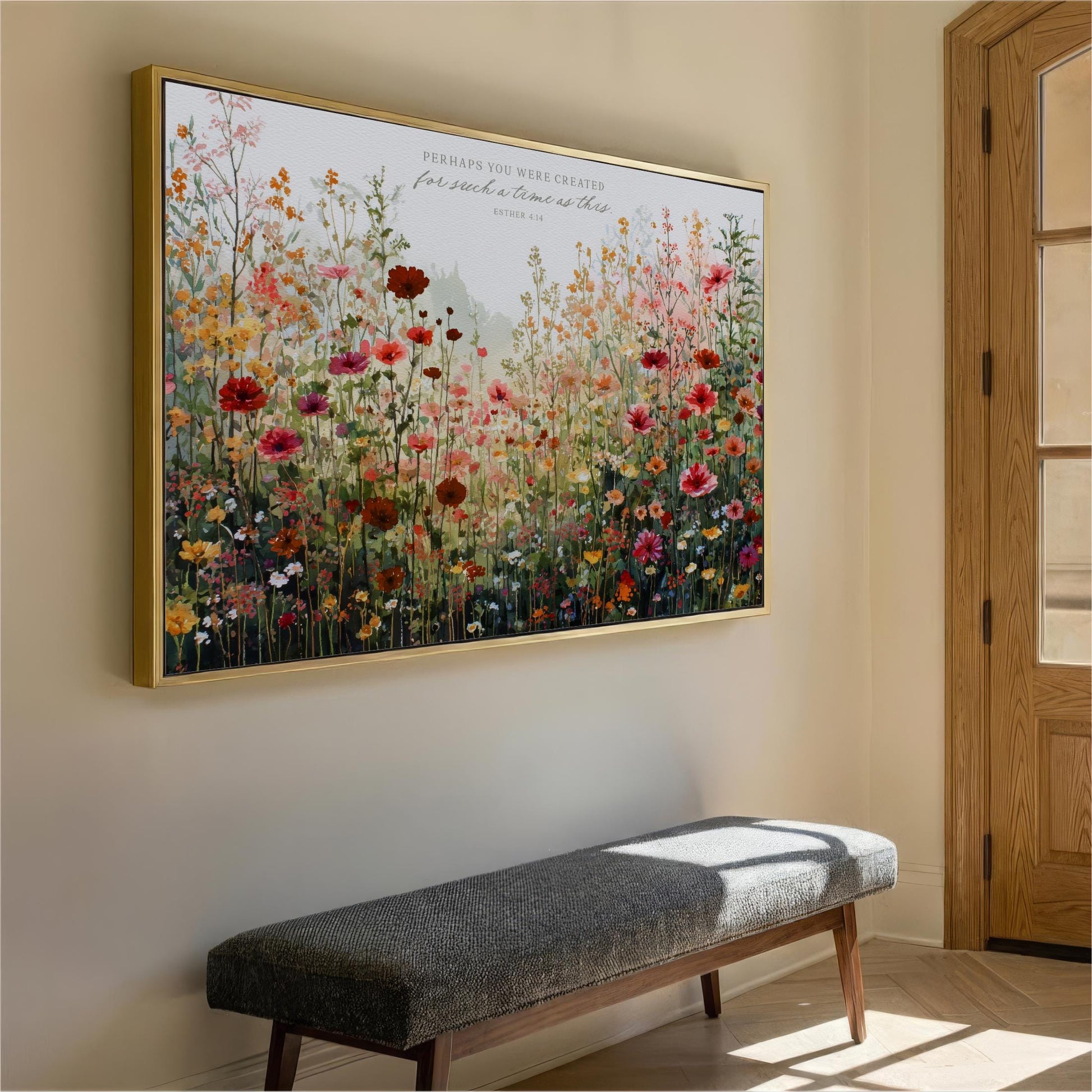 a large, colorful painting of a field of flowers hanging on a wall. Below the painting, there is a gray bench placed against the wall.